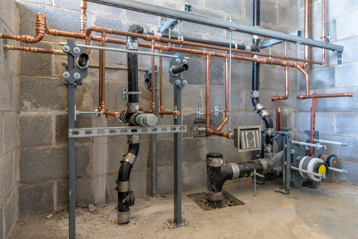 Commercial bathroom plumbing rough-in in a block wall